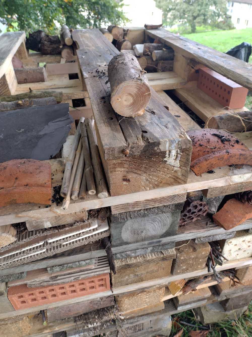 A close up of the insect hotel mid-way through construction, showing all the filler materials arranged on the outside