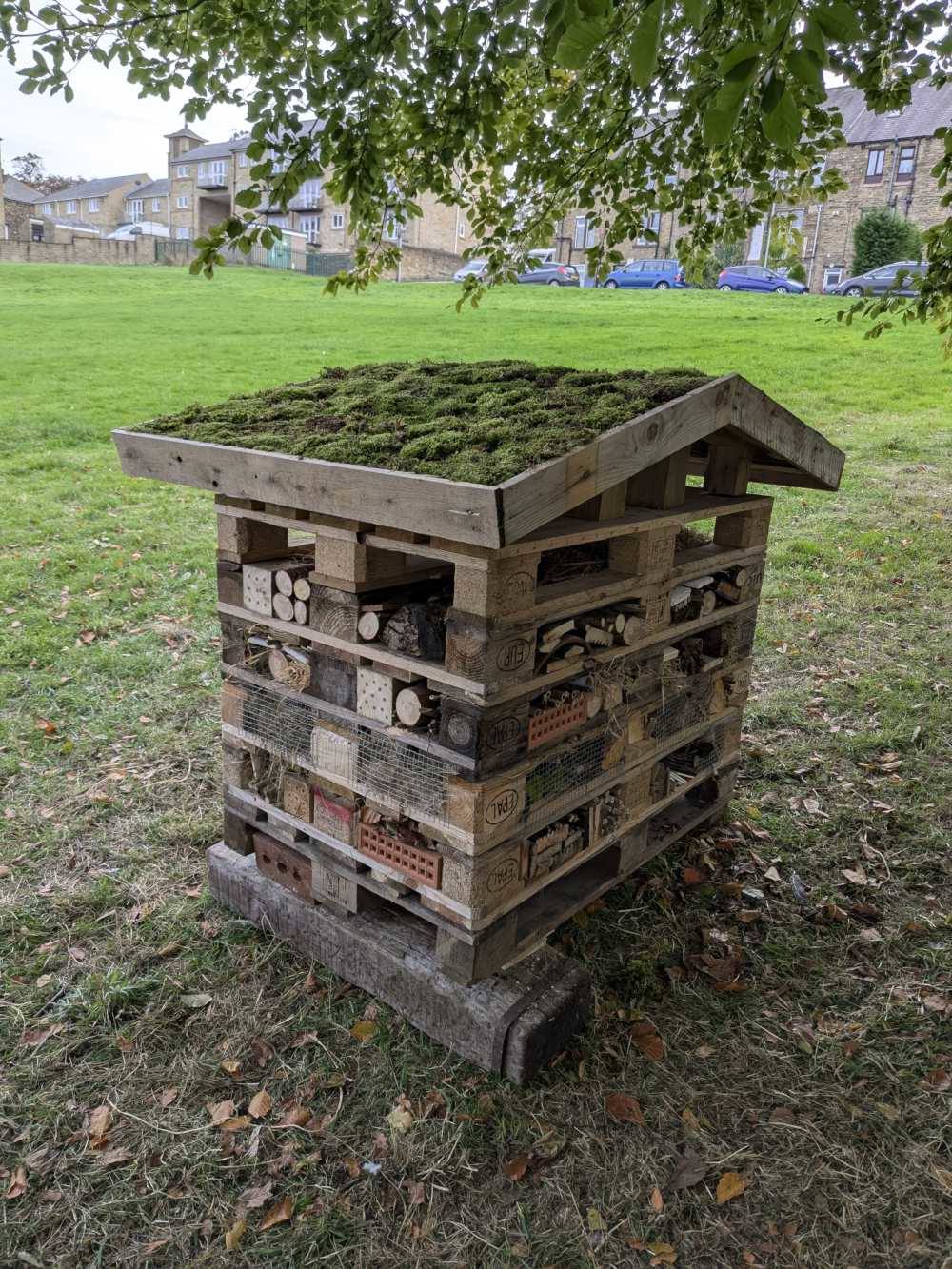 The completed insect hotel, with the roof on and only one pallet left to fill